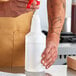 A man pouring liquid into a white Lavex plastic bottle.