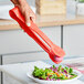 Red Polycarbonate Flat Grip Tongs being used to serve salad