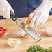 A person grating a ginger on a Microplane coarse grater over a bowl of food.