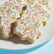 A plate of cookies with frosting and Adourne Rainbow Sparkling Sugar sprinkles.