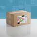 A brown cardboard box with a colorful sticker for Adourne Coarse Rainbow Sanding Sugar.