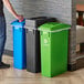 A man standing next to a Lavex 3-stream rectangular trash station with black, green, and blue lids.