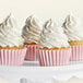 A group of cupcakes with white frosting on top.