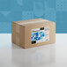 A brown cardboard box with blue and white labels for Adourne Coarse Blue Sanding Sugar.