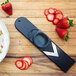 A Microplane mini mandoline slicer with strawberries on a wooden surface.