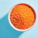 A bowl of Adourne orange sparkling sugar.