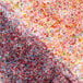 A close up of a colorful pile of Adourne Coarse Green Sanding Sugar.