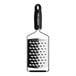 A close-up of a Microplane Gourmet black ultra-coarse grater with a white surface.