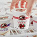 A hand holding a September Farm Raspberry yogurt container.