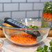 A Microplane grater in a bowl of carrots.