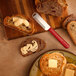 A Microplane 3-in-1 Butter Blade on a piece of bread on a wooden surface.