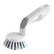 A white handheld scrubber brush with stiff bristles and an ergonomic handle.