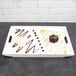 A white rectangular porcelain platter with brownies and blueberries on it.