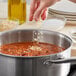 McCormick Culinary Dehydrated Chopped Onion being poured into a pot of food.