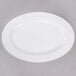A white oval porcelain platter on a gray surface.