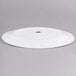 A white oval porcelain platter with a hole in the middle.