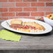 A white porcelain oval platter with a variety of meats and cheese on a table.