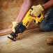 A man using a DeWalt cordless reciprocating saw.