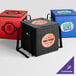 A red Sterno insulated food carrier with a logo on it.