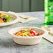 Two Dart ProPlanet fiber bowls filled with salad and vegetables on a table.