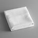 A folded white Intedge table cover on a gray surface.