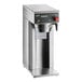 A silver Curtis airpot coffee brewer with black digital controls.