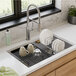 A Zurn Elkay Crosstown stainless steel sink with dishes on a rack above it.