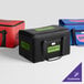 A large black Sterno insulated catering food carrier with green labels.