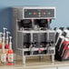 A Curtis Gemini stainless steel coffee machine with servers on a table in a corporate cafeteria.