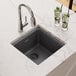 A Zurn Elkay Quartz Classic bar sink filled with a glass of water, ice, and lime slices on a counter.