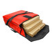 A red Sterno insulated pizza carrier with several pizza boxes inside.