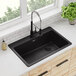 A Zurn Elkay black Quartz drop-in sink with a faucet and a plant on the counter.