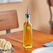 A Choice oil and vinegar cruet on a restaurant table with bread.