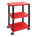 A red and black plastic Luxor utility cart with three shelves and wheels.