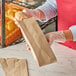 A person in gloves holding a brown Kraft bread bag.