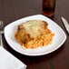 A Carlisle white square melamine plate with spaghetti and meatballs on it.