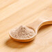 A wooden spoon with Rainforest Supply Organic Lucuma Powder.
