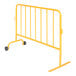 A yellow steel crowd control barrier with wheeled feet.