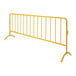 A yellow steel crowd control barrier with curved metal legs.