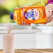A person pouring Dial liquid hand soap into a container.