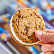 A hand holding a Blue Bunny Big Bopper frozen dessert sandwich.