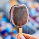 A hand holding a DOVE Dark Chocolate Ice Cream Bar on a stick.