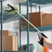 A hand using a Lavex Trigger Grip Reaching Tool to cut a box.