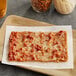 A rectangular slice of Tony's SMARTPIZZA on a wooden board.