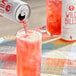 A person pouring Wild Bill's Strawberry Cream Soda from a can into a glass.