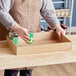 A man holding a Choice Kraft corrugated tray with a green can inside.