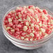 A bowl of Yum Crumbs Strawberry Shortcake crumb topping with pink and white pieces.