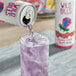 A person pouring Wild Bill's Ring Pop Berry Blast soda from a can into a glass.