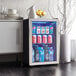 A compact stainless steel glass door beverage refrigerator filled with assorted drinks.