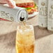 A hand holds a can of Wild Bill's Vanilla Cream Soda with a white label.